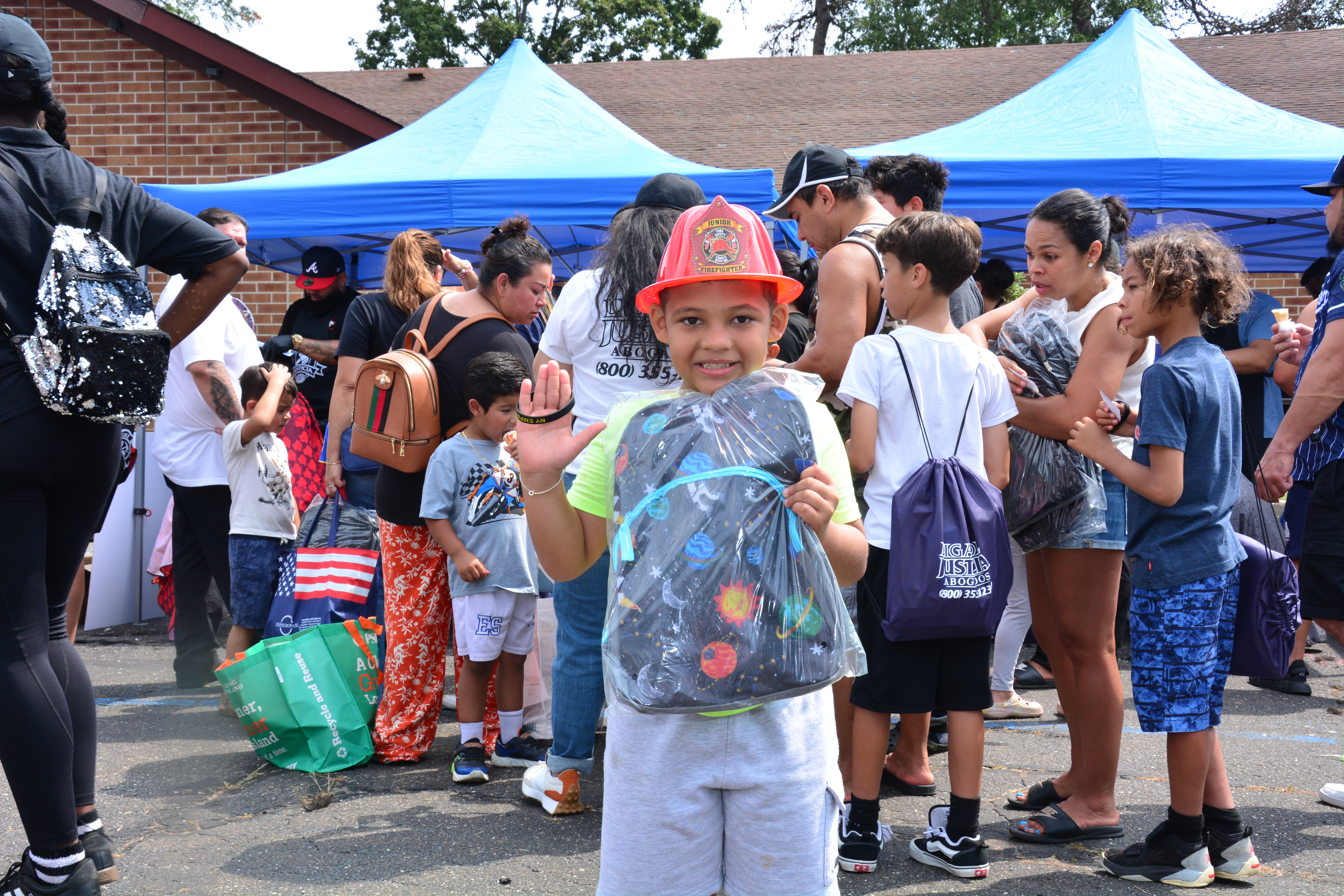 A child holds a backpack at a school supply distribution event on Aug. 16, 2025.