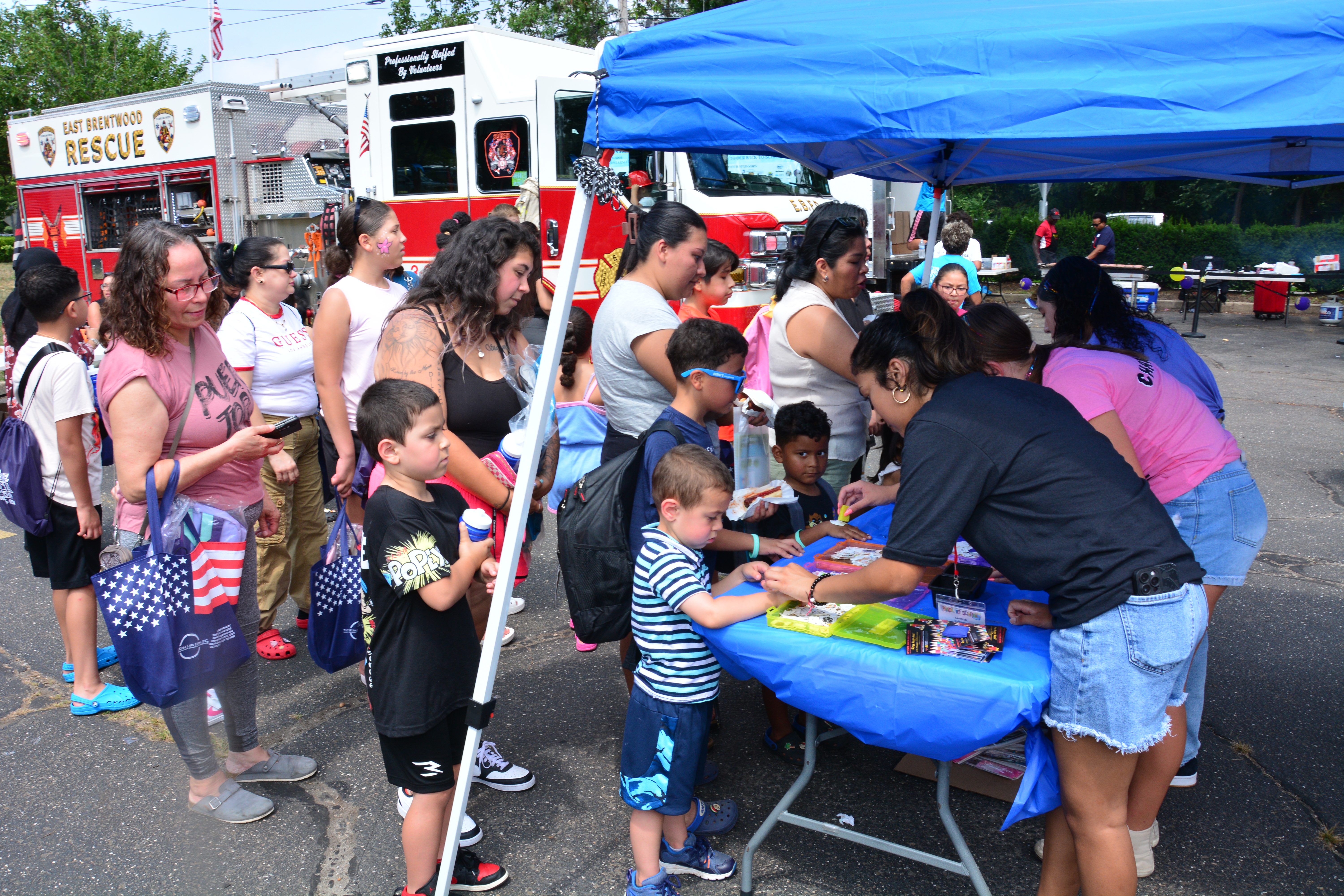 Children get temporary tattoos during a backpack and school supply distribution event in Brentwood on Aug. 16, 2025.