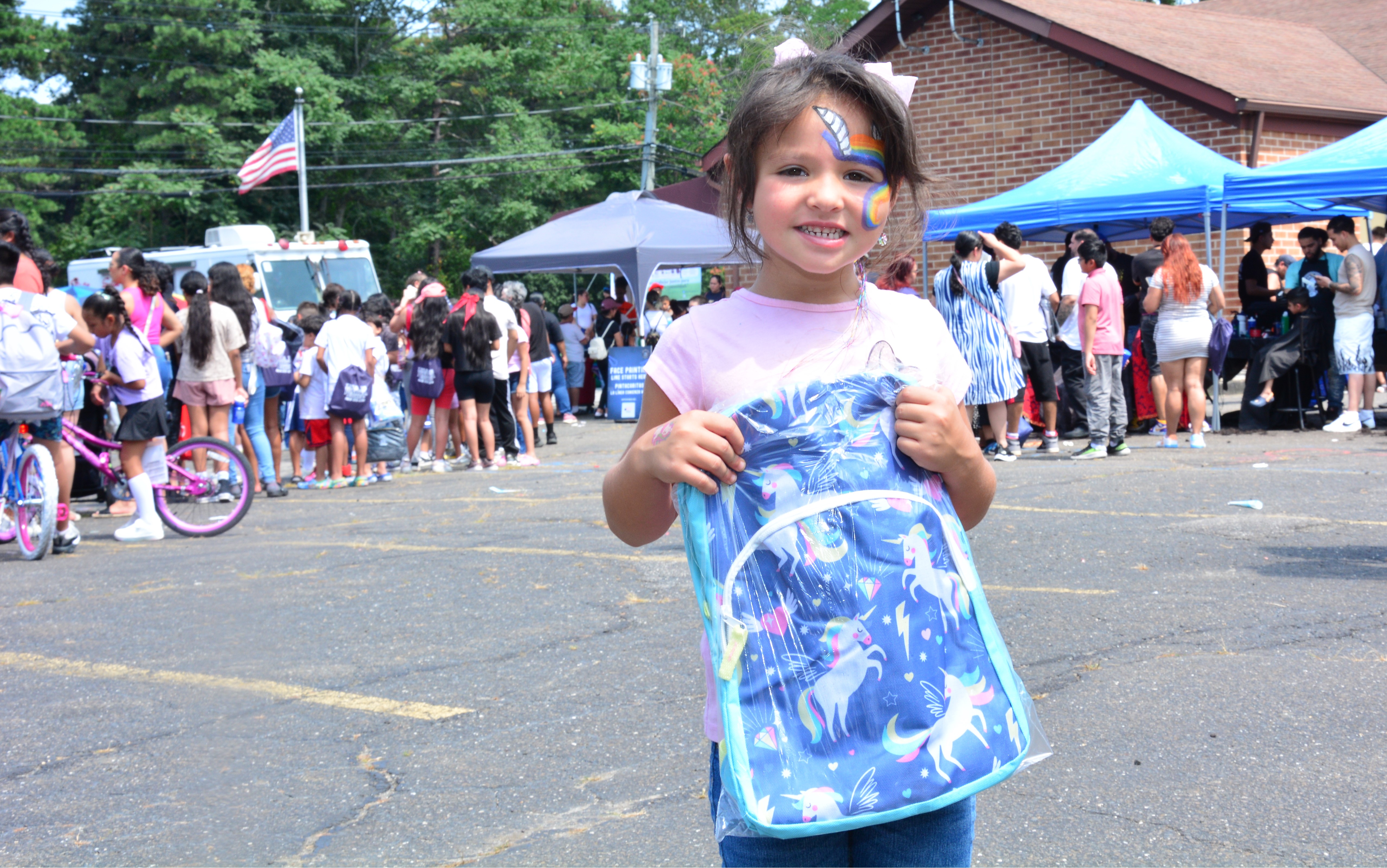 A child hold a new backpack during a school supply distribution event held on Aug. 16, 2025 in Brentwood.