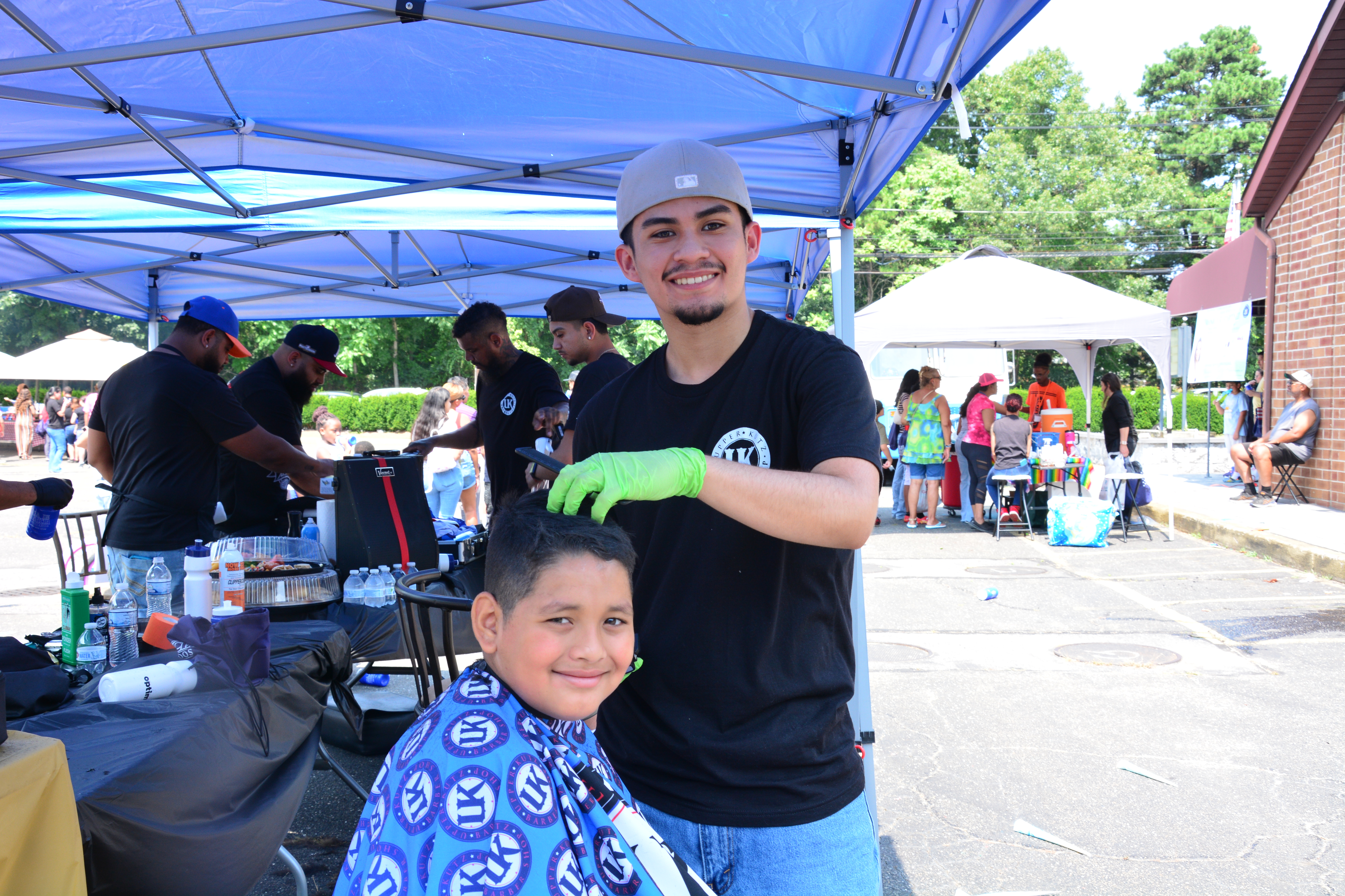 A student gets a haircut from a barber during the Brentwood backpack and school supply event on Saturday, Aug. 16, 2025.