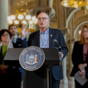 Senator Sutton speaking at a podium