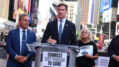 Senator Erik Bottcher and Assemblymember Tony Simone stand together at a press conference in Times Square.