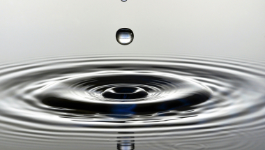Photo image of a water drop and water ripples.