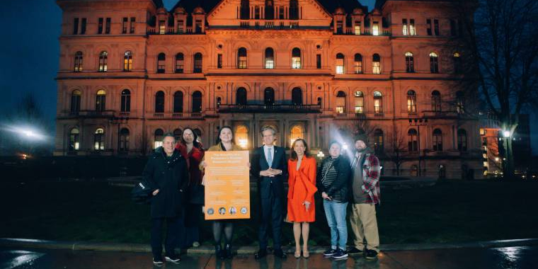 Senator Hoylman Sigal, AM Paulin, Advocates outside the capitol building, lit orange