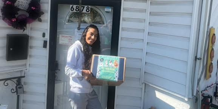 Yanira Laboy, the shelter manager for PuppyKittyNYCity, displays the donations received from Senator Adabbo's Office.