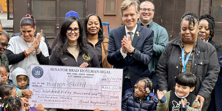 Senator Hoylman-Sigal presenting giant check with children at Amsterdam Houses
