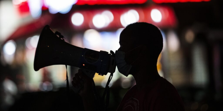 A gun violence prevention worker addresses people gathered for an event in New York City’s Harlem neighborhood in 2020. New York is one of three states that established or expanded gun violence prevention offices this year. Frank Franklin II/AP Photo