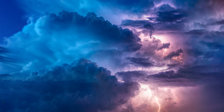 Photo image of storm clouds with streaks of lightning.