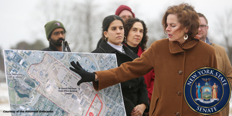 Sen Fahy and AM Romero standing in front of a sign of the proposed Wadsworth Labs site