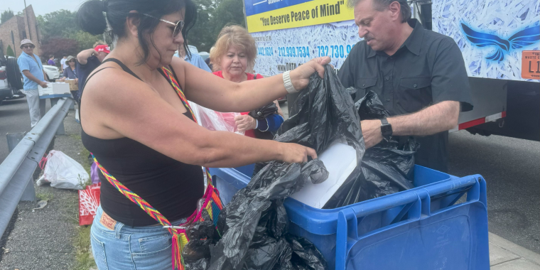 Senator Addabbo helps constituents empty their bags of paper to be shredded.