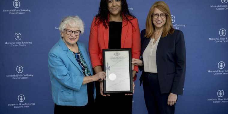 A photo of Senator Toby Ann Stavisky, Assemblymember Linda B. Rosenthal, and Dr. Cardinale Smith (Chief Medical Officer), holding the signed pen certificate of the Scalp Cooling Insurance Law
