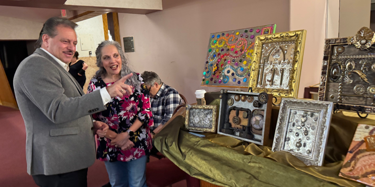 Senator Addabbo admires mixed media collages created by Amy Handy.