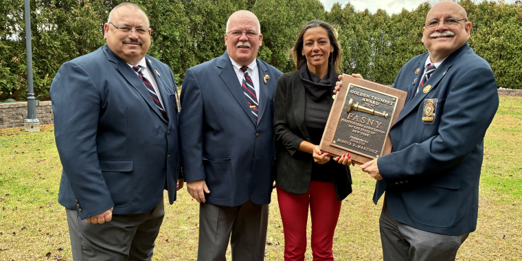 Photo of New York State Sen. Monica R. Martinez begin presented the Golden Trumpet Award by FASNY.