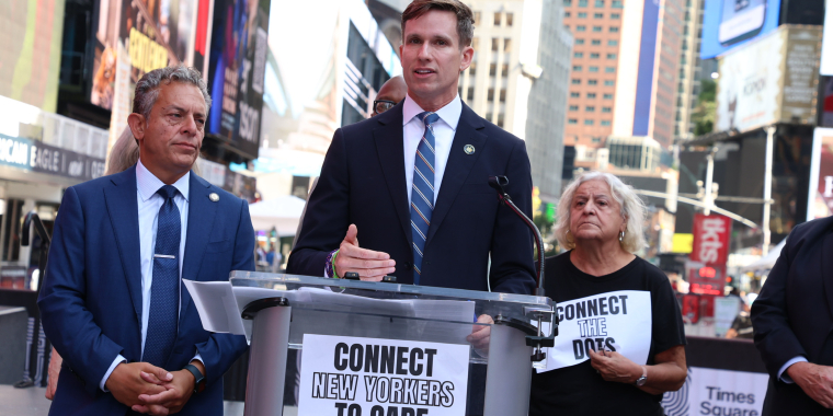 Senator Erik Bottcher and Assemblymember Tony Simone stand together at a press conference in Times Square.