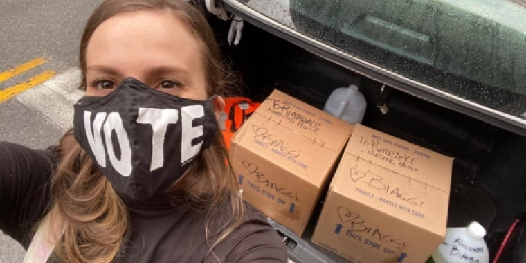 Senator Biaggi takes a selfie wth boxes of hand sanitizer in the background