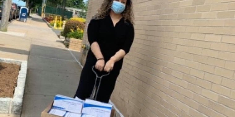 A volunteer pulls wagon of masks being delivered 